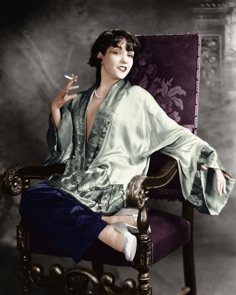Портрет молодої жінки, яка палить цигарку і посміхається — стокове фото