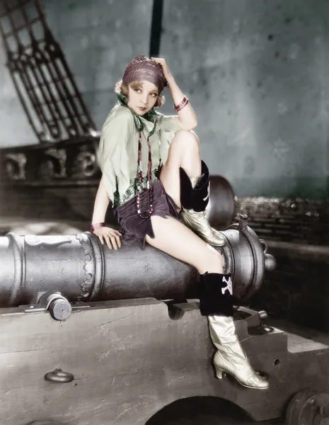Profil d'une jeune femme assise sur un canon et réfléchissant — Photo