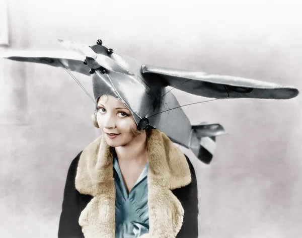 Retrato de uma jovem mulher usando um boné em forma de avião — Fotografia de Stock