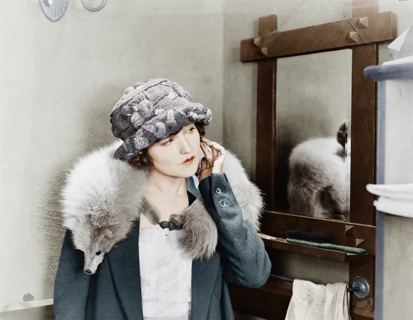 Mujer joven con una estola de zorro en los hombros y ajustando su pendiente — Foto de Stock