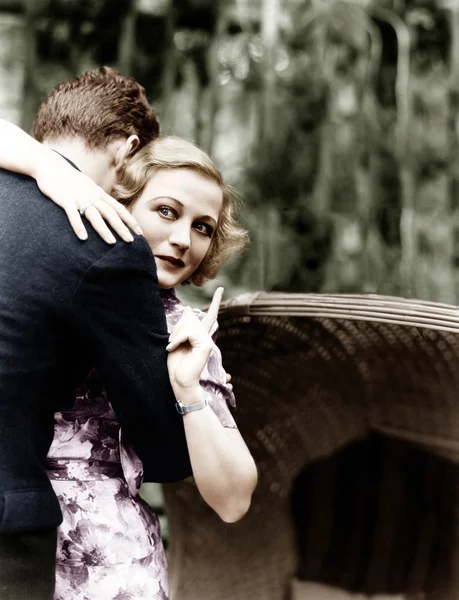 Mujer joven abrazando a un hombre y señalando hacia un tablero de información —  Fotos de Stock