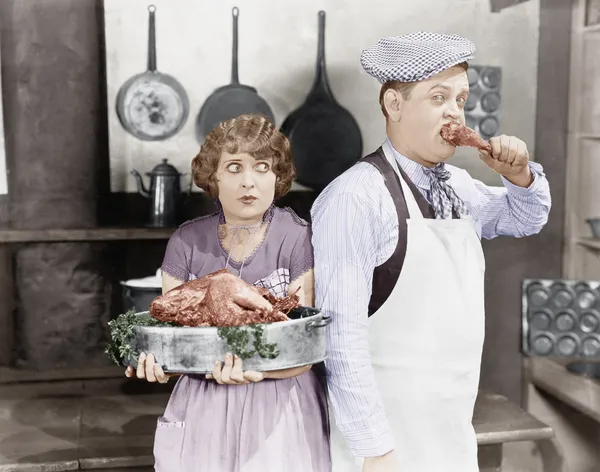 Ζευγάρι στέκεται μαζί σε μια κουζίνα με ένα μαγειρεμένο γαλοπούλα — Φωτογραφία Αρχείου