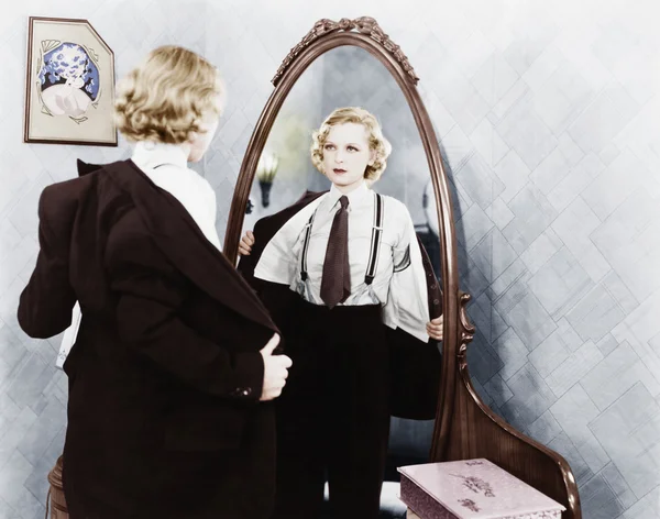 Junge Frau in Männerkleidung zieht sich vor Spiegel aus — Stockfoto