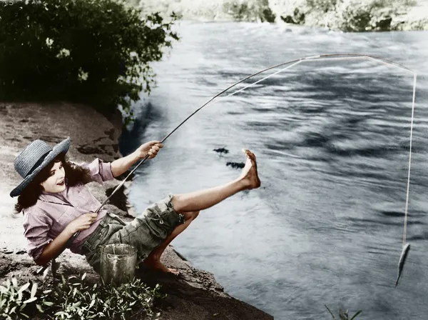 抓到一条小鱼向后摔倒的女人 — 图库照片