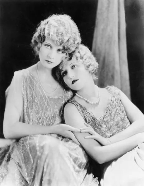 Dos mujeres elegantes sentadas juntas Imagen de archivo