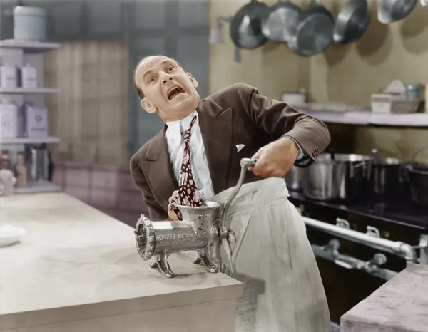Man with tie stuck in meat grinder — Stock Photo, Image