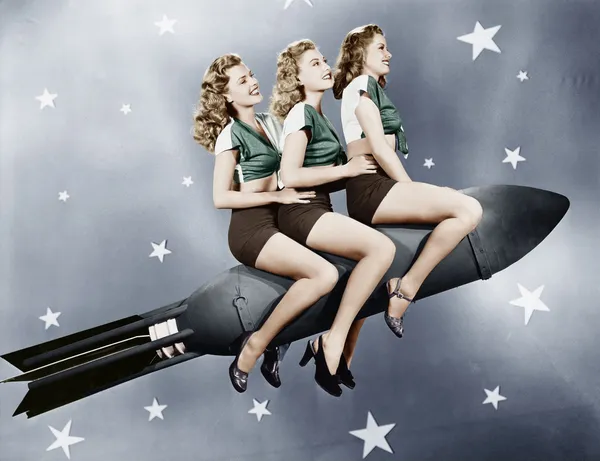 Drie vrouwen zittend op een raket Stockfoto