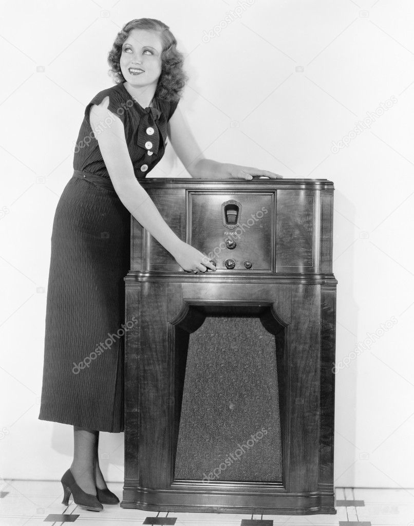 Woman next to a radio turning the knobs
