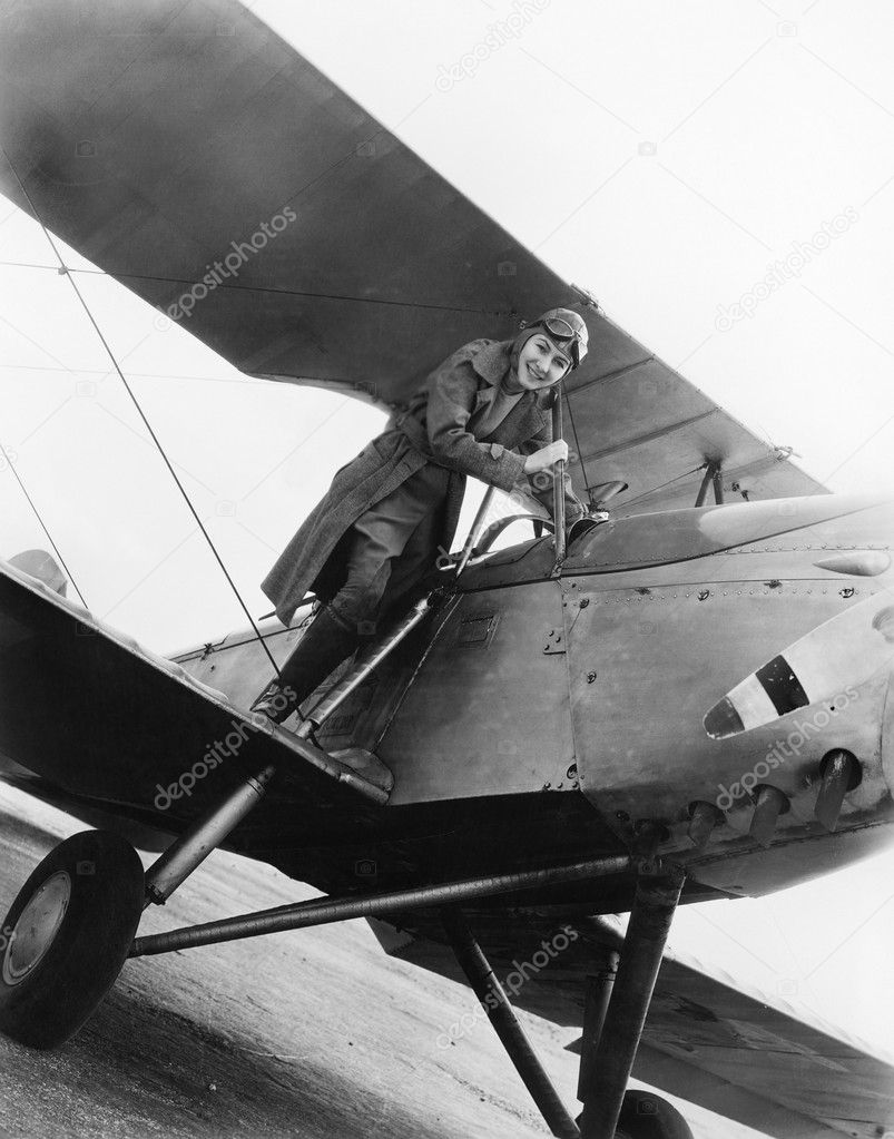 Young woman standing on the wing of an airplane