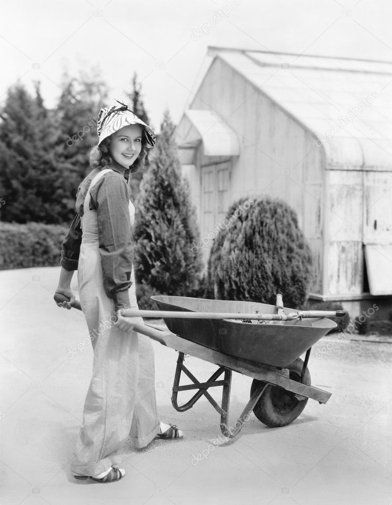 Woman walking with a wheel barrel