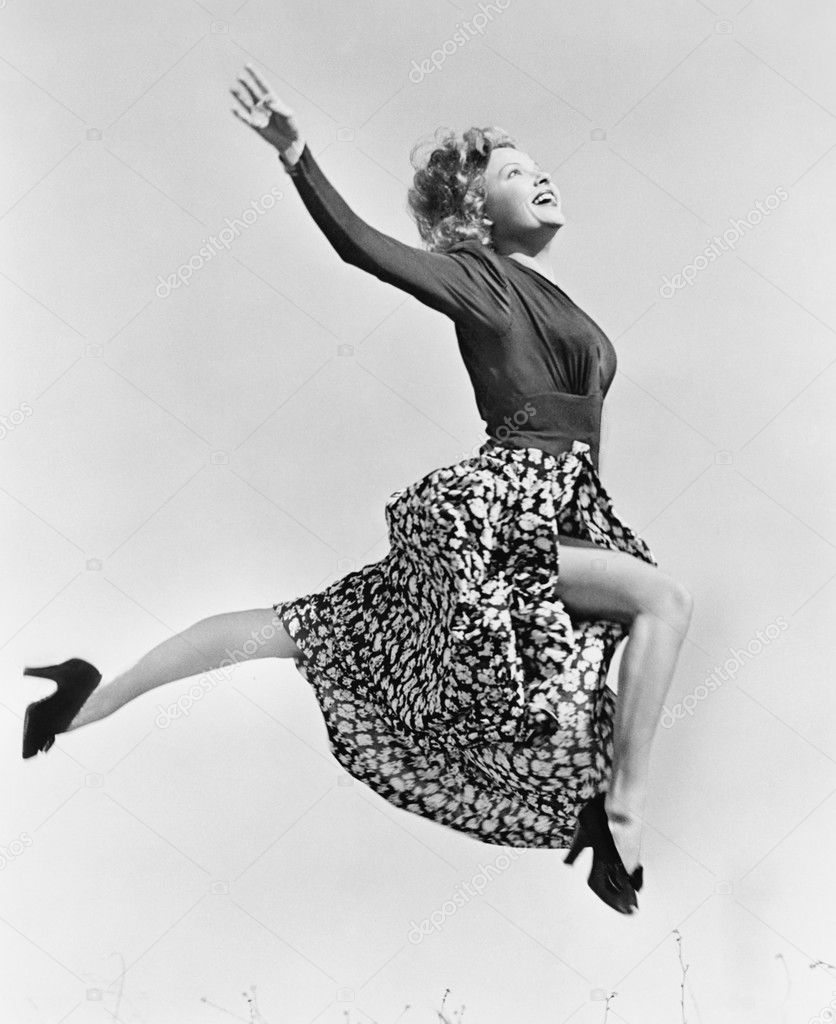 Woman in a flowing skirt leaping through the air