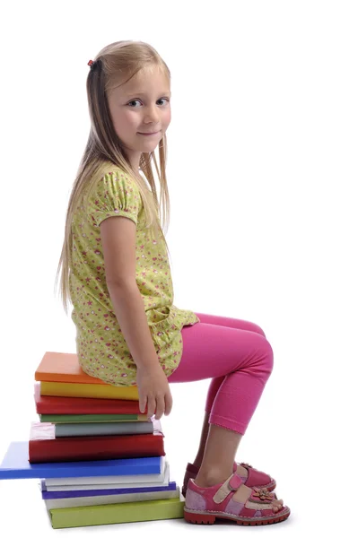 Girl seated on a stack of books — Stock Photo, Image