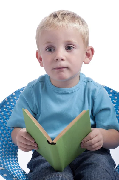 Tagträumender kleiner Junge liest ein Buch — Stockfoto