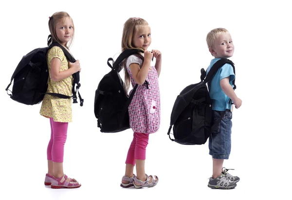 Childeren in a row with backpacks — Stock Photo, Image