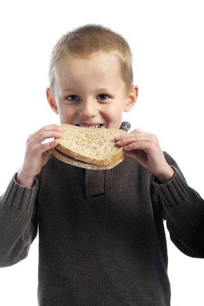 Milý chlapeček jíst plátky chleba — Stock fotografie