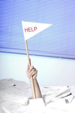 Hand with help flag sticking out of a desk with papers clipart