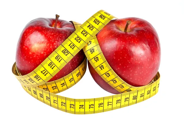 Красные яблоки с измерительной лентой — стоковое фото