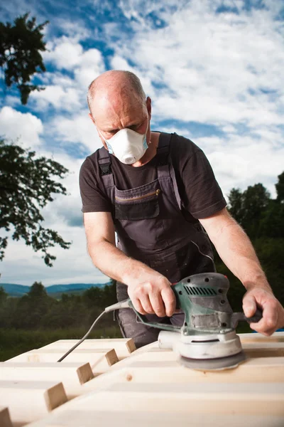 Carpintero lijando una madera con lijadora —  Fotos de Stock