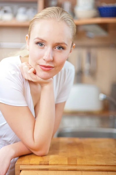 Bela mulher relaxada de pé na cozinha — Fotografia de Stock