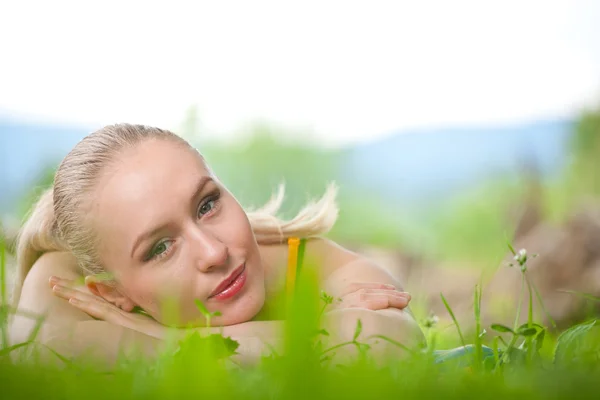 Młoda kobieta, leżące w trawie — Zdjęcie stockowe