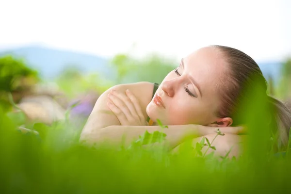 Jeune femme couchée dans l'herbe — Photo