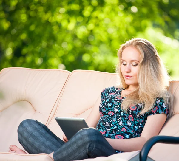 Positiv, vakker ung kvinne som sitter utendørs i lenestol – stockfoto
