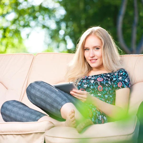 Positiv, vakker ung kvinne som sitter utendørs i lenestol – stockfoto