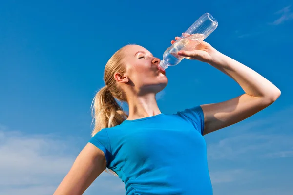 Fiatal női sportoló drinkig víz alatt meleg időjárás frissítése — Stock Fotó