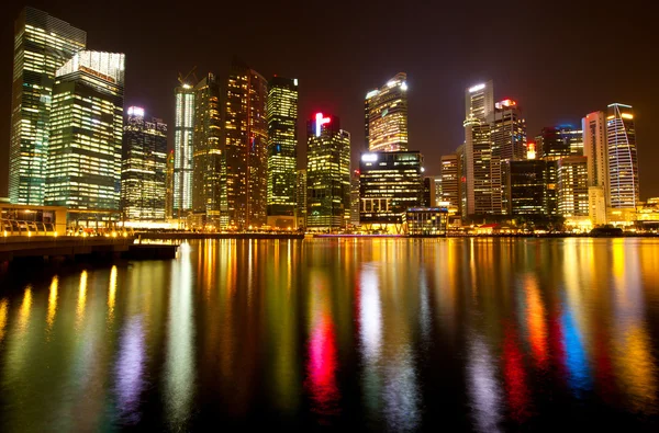 Een weergave van singapore business district in de nachttijd met water reflecties. — Stockfoto