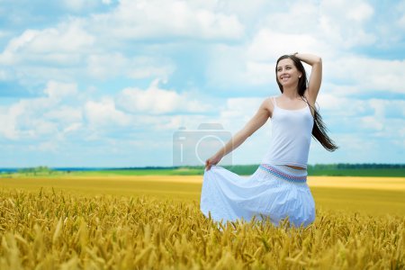 Brunette marche dans le champ de blé 